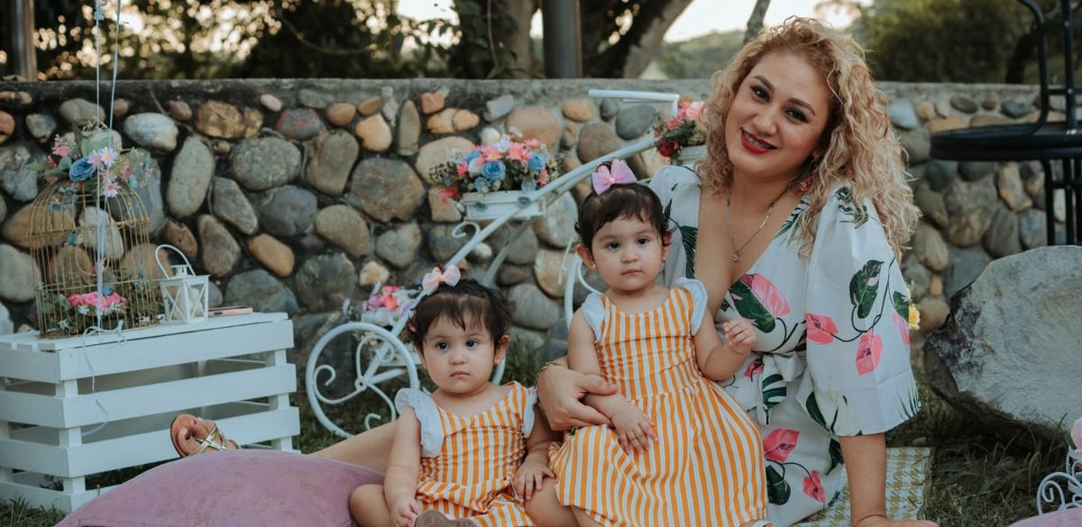 A joyful family picnic in La Dorada, Colombia featuring a mother and her two children outdoors.