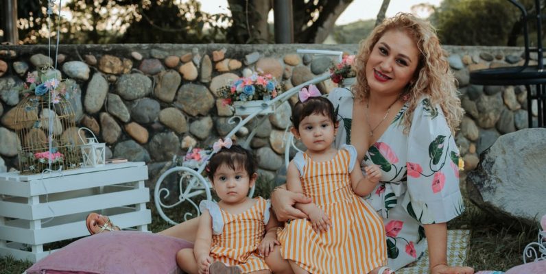 A joyful family picnic in La Dorada, Colombia featuring a mother and her two children outdoors.