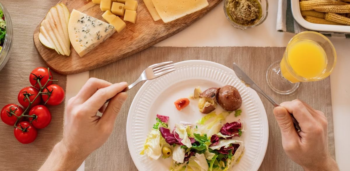 A vibrant lunch setting with salad, cheese, and orange juice, perfect for a healthy meal.