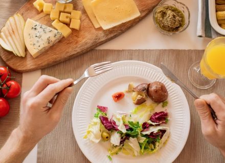 A vibrant lunch setting with salad, cheese, and orange juice, perfect for a healthy meal.