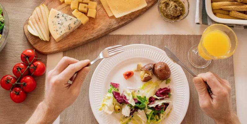 A vibrant lunch setting with salad, cheese, and orange juice, perfect for a healthy meal.